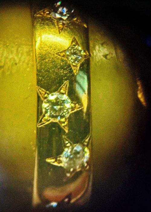 diamonds in a star setting in a gold ring